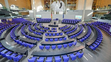Berlin: Der Plenarsaal des Deutschen Bundestages mit den blauvioletten, jedoch leeren Stühlen, in der Mitte des Reichstagsgebäudes (Archivbild) | Bild: picture alliance / SULUPRESS.DE | Marc Vorwerk